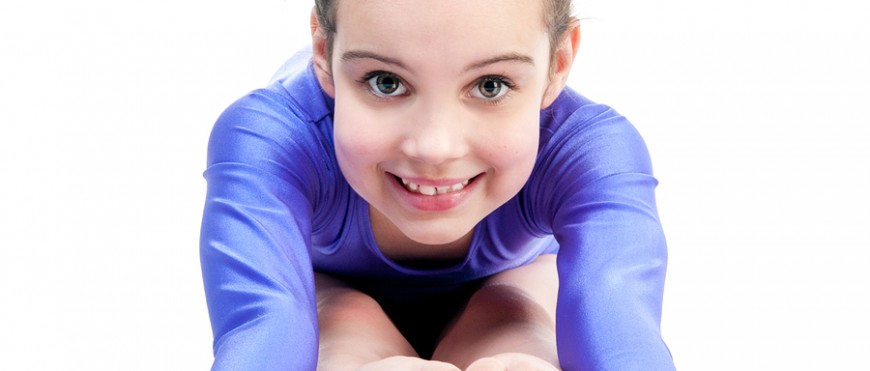 young girl doing gymnastics isolated over white background